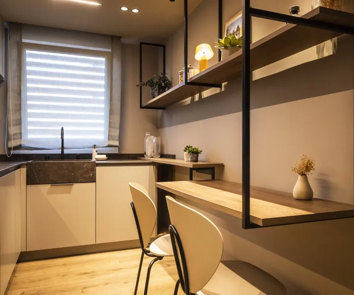 Cocina de acabados claros con una barra de apoyo