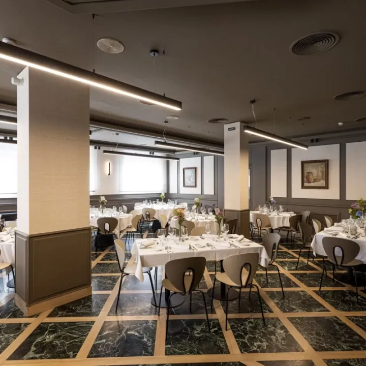Comedor con mesas y columnas en un interior abierto