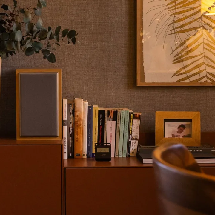 Estantería y mesa auxiliar con libros e iluminación cálida