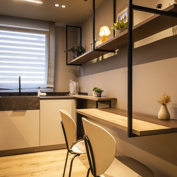Cocina de acabados claros con una barra de apoyo